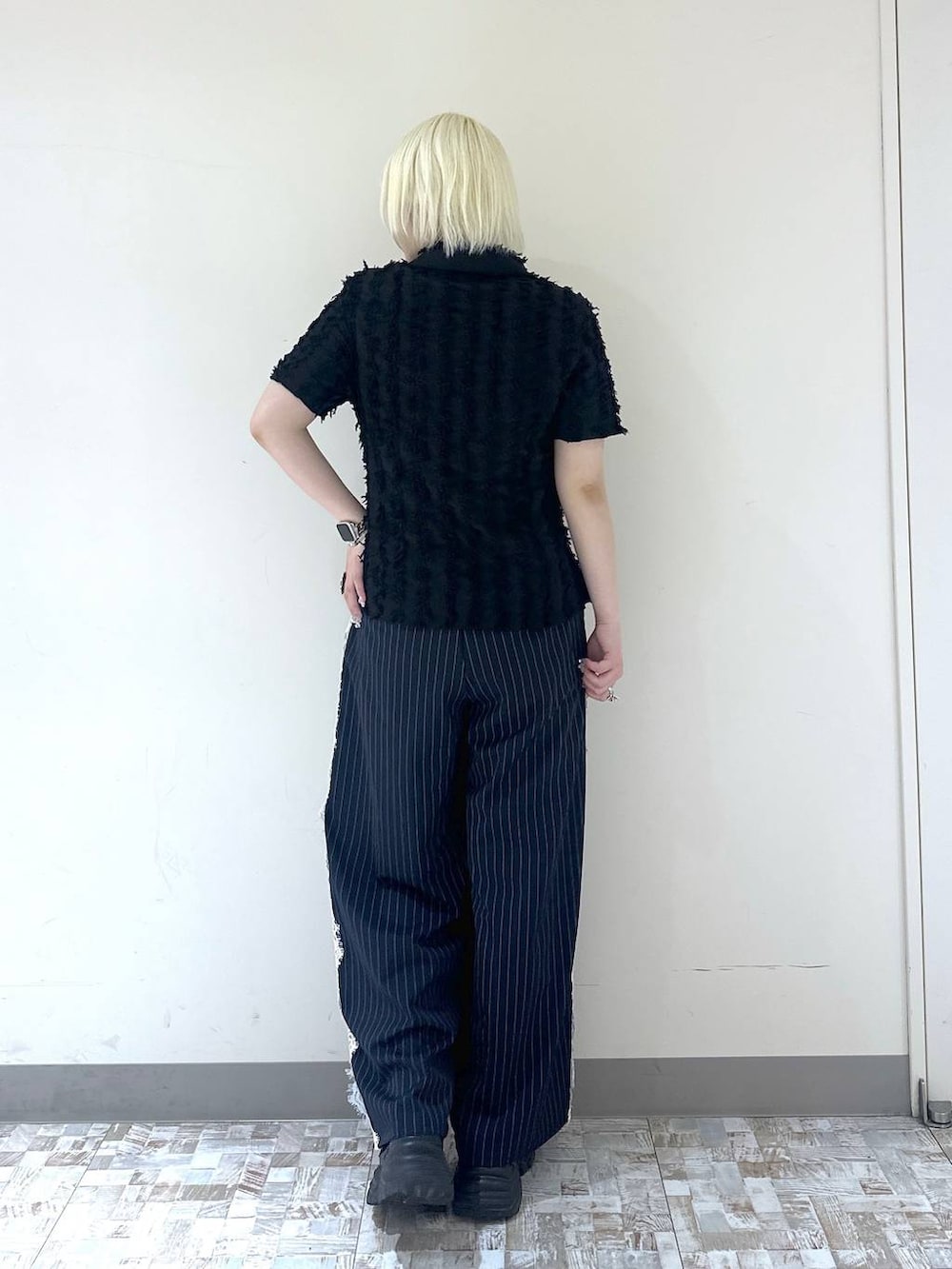 ブラック系のスニーカー、ブルー系のスラックス、ブラック系のシャツ/ブラウスを着用したレディースの夏コーディネートの5枚目の写真