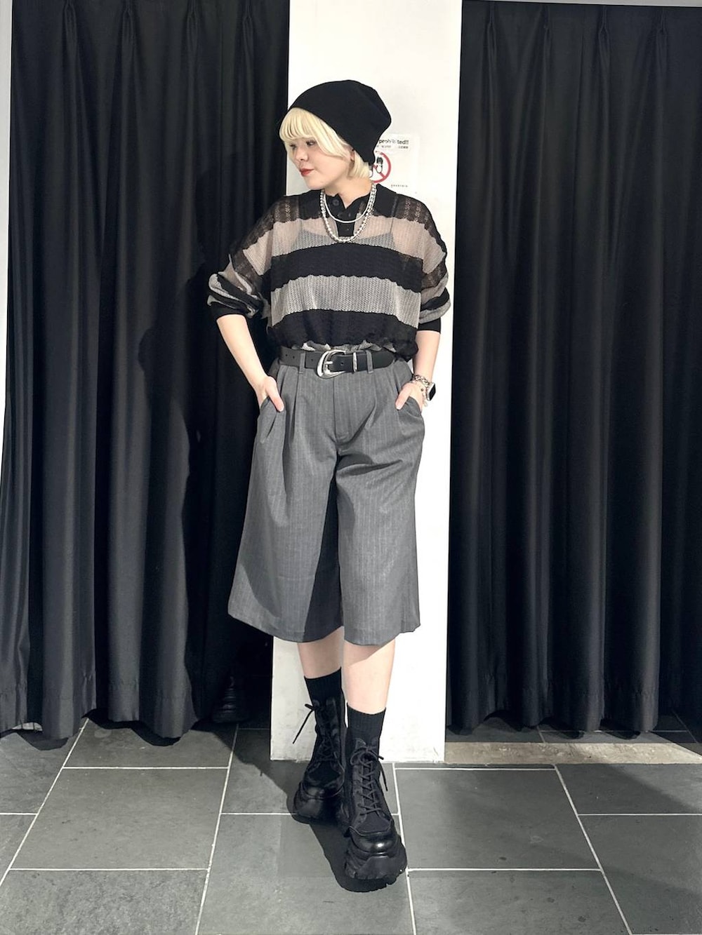 ブラック系のブーツ、グレー系のポロシャツ、グレー系のスラックスを着用したレディースの春コーディネートの2枚目の写真