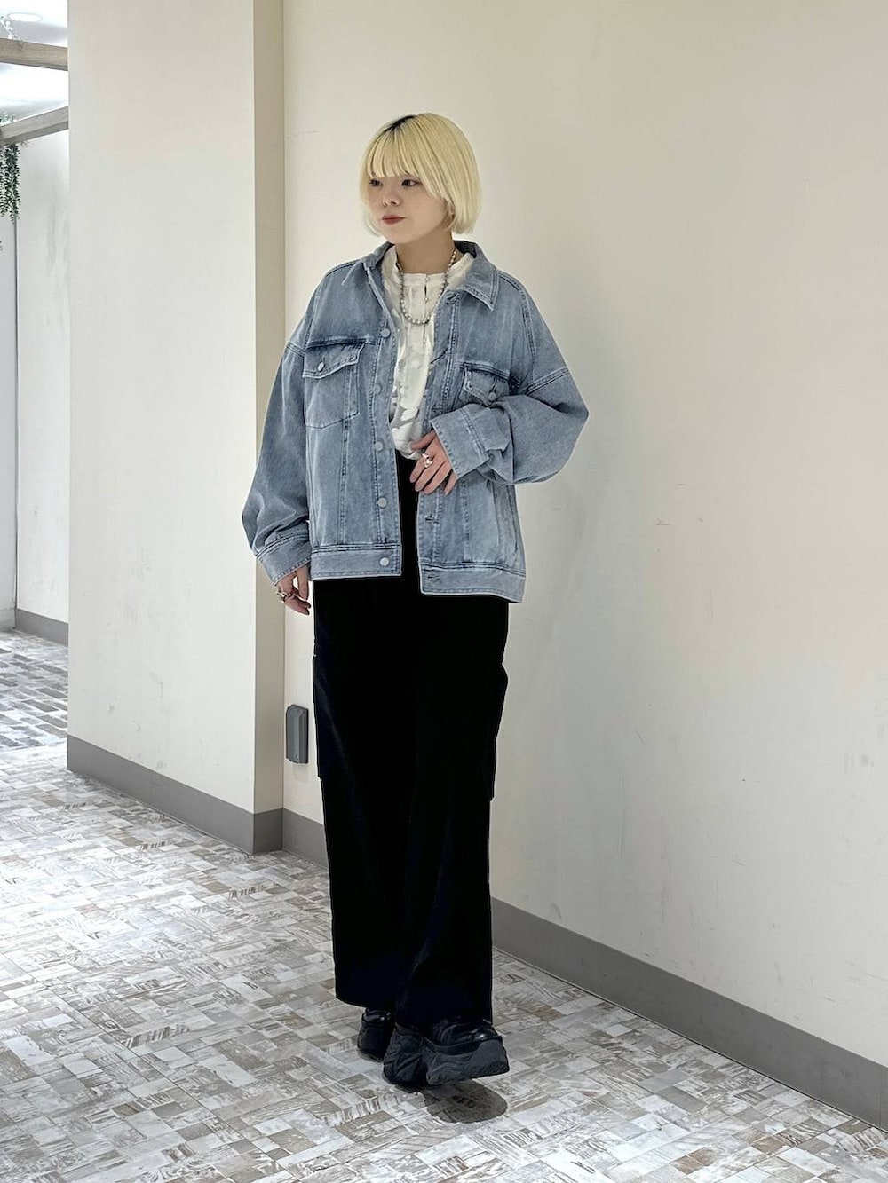 ブラック系のスニーカー、ブルー系のブルゾン、ホワイト系のTシャツ/カットソーを着用したレディースの冬コーディネートの2枚目の写真