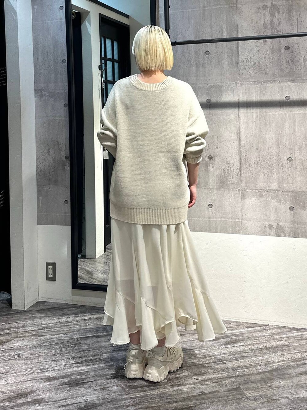 ホワイト系のスカート、ホワイト系のバレエシューズ、ホワイト系のニット/セーターを着用したレディースの冬コーディネートの3枚目の写真