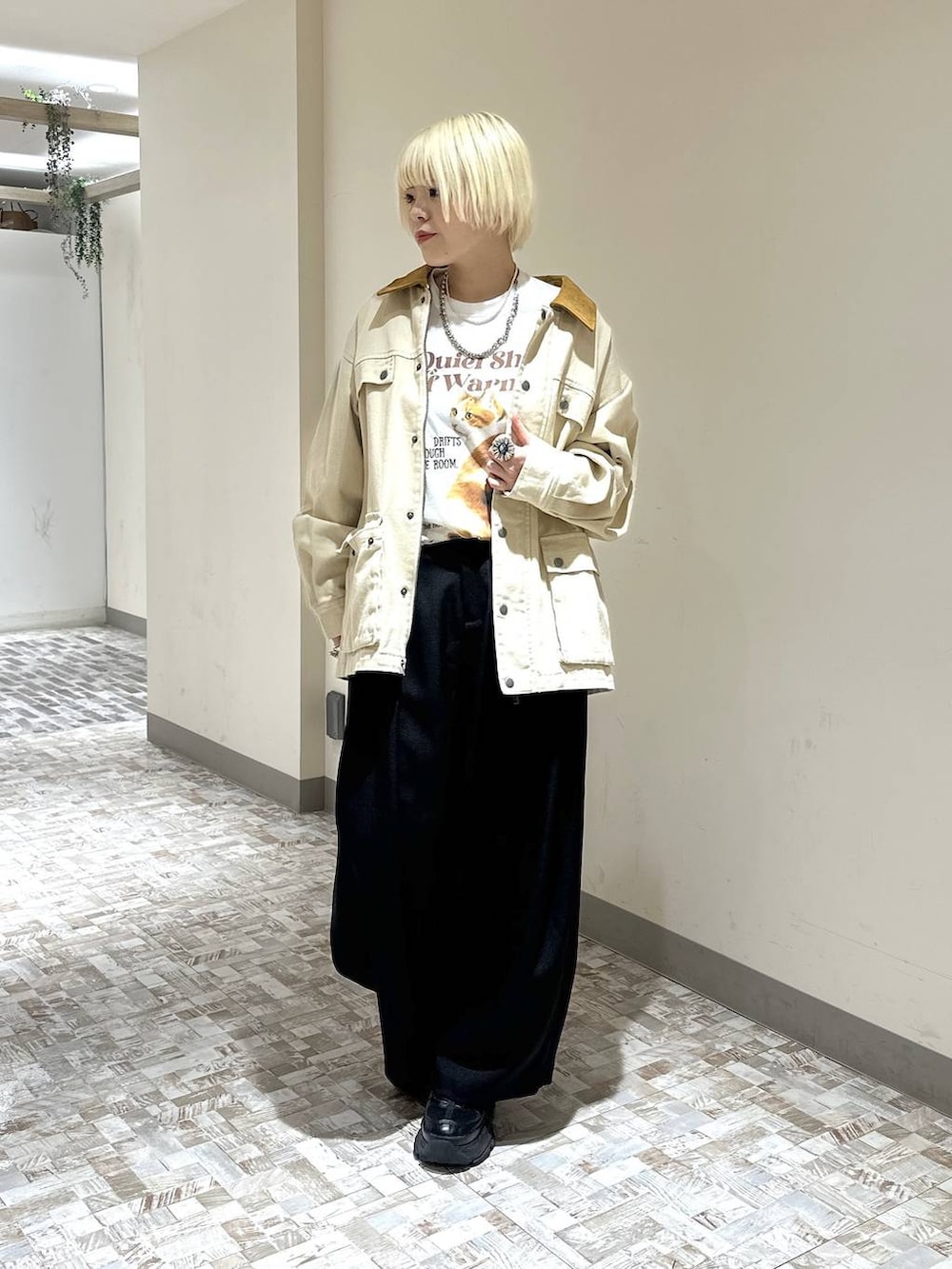 ブラック系のスニーカー、ホワイト系のTシャツ/カットソー、ブラック系のスラックスを着用したレディースの春コーディネートの2枚目の写真