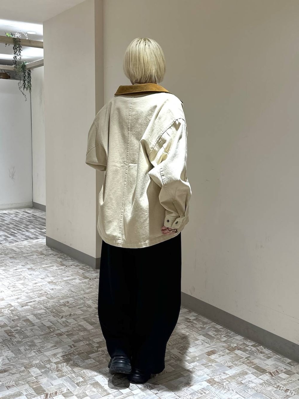 ブラック系のスニーカー、ホワイト系のTシャツ/カットソー、ブラック系のスラックスを着用したレディースの春コーディネートの4枚目の写真