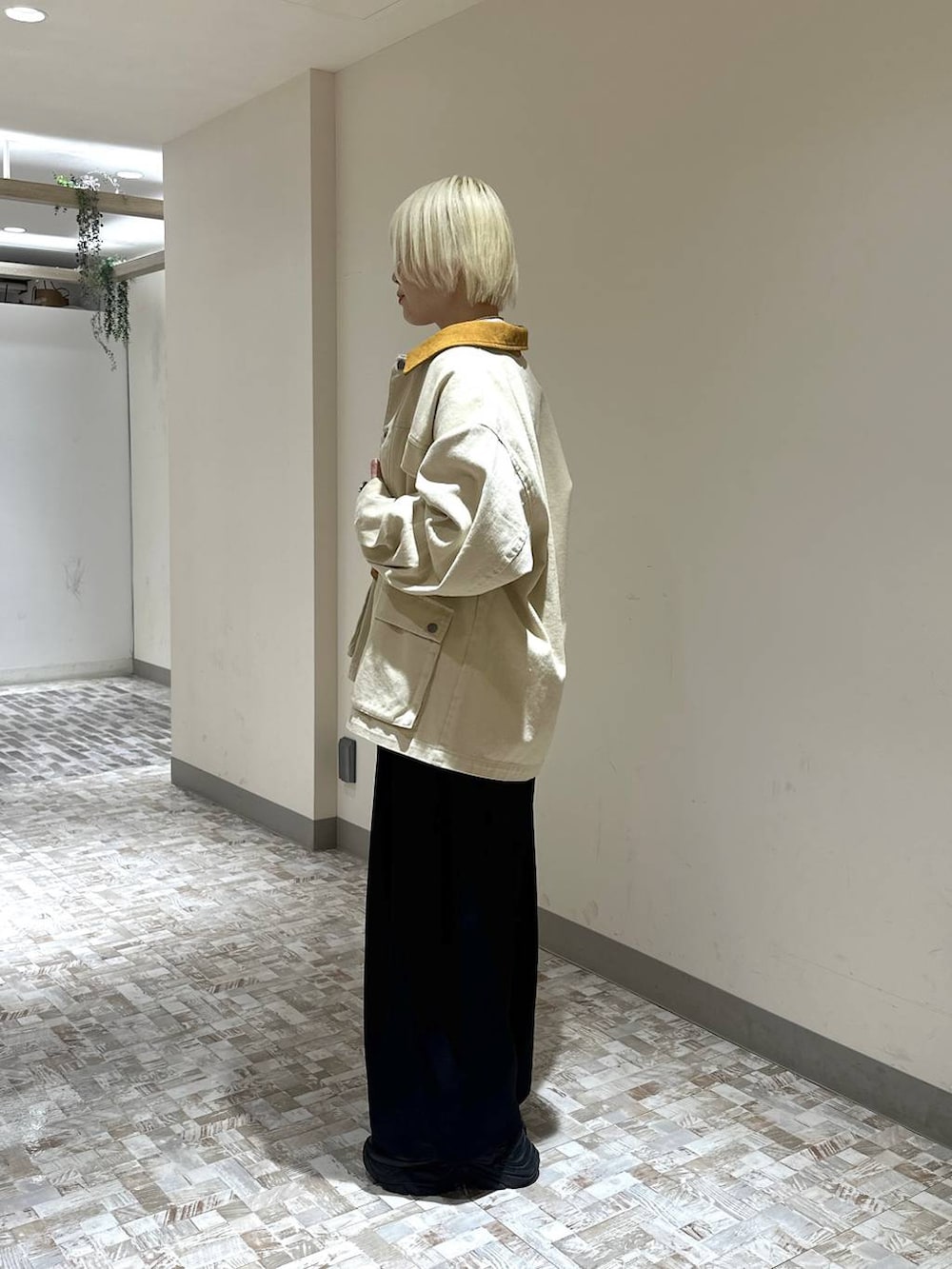 ブラック系のスニーカー、ホワイト系のTシャツ/カットソー、ブラック系のスラックスを着用したレディースの春コーディネートの3枚目の写真