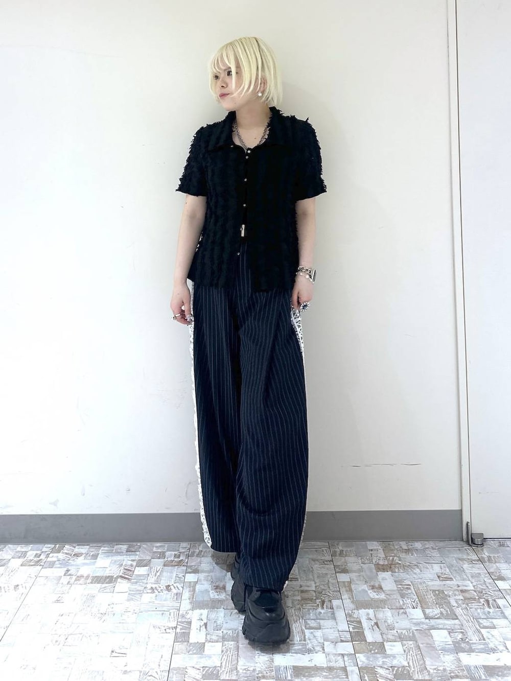 ブラック系のスニーカー、ブルー系のスラックス、ブラック系のシャツ/ブラウスを着用したレディースの夏コーディネートの2枚目の写真