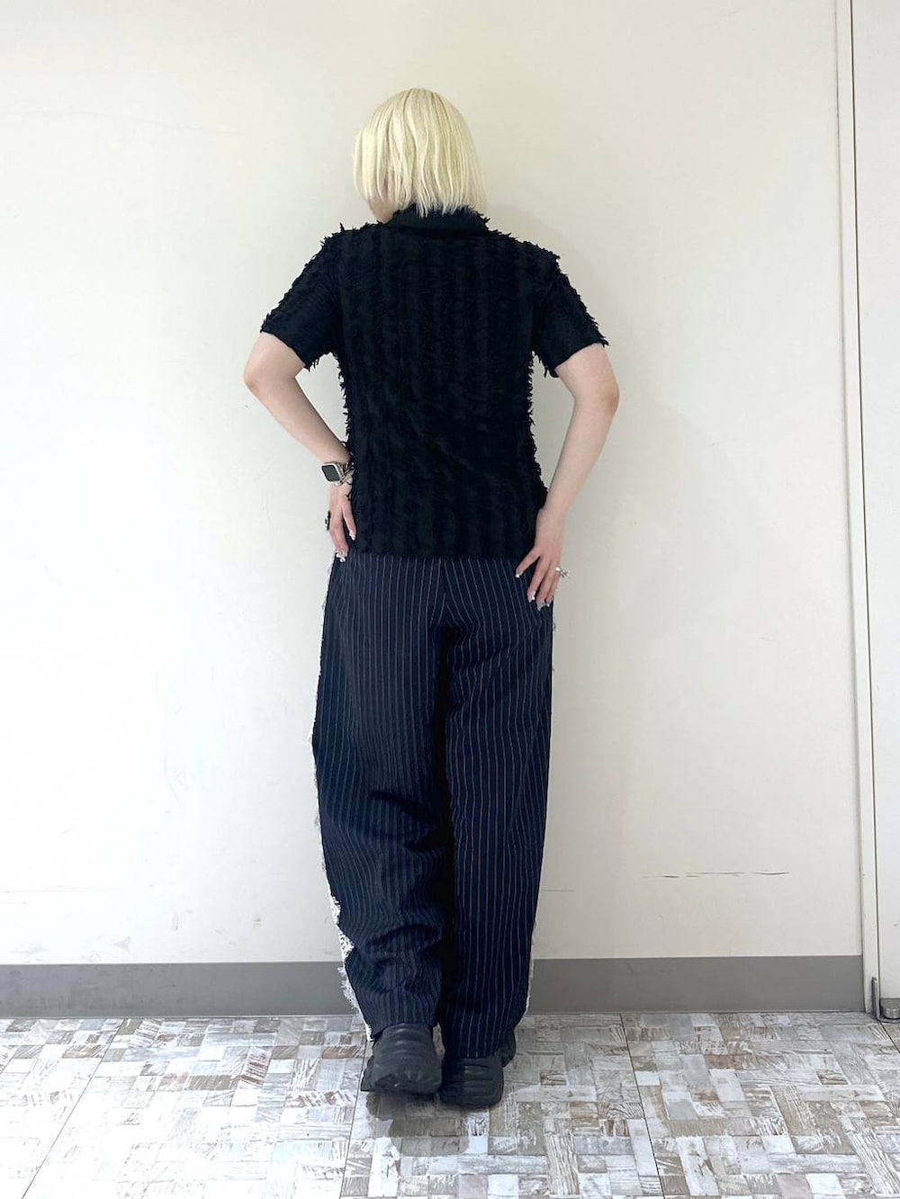 ブラック系のスニーカー、ブルー系のスラックス、ブラック系のシャツ/ブラウスを着用したレディースの夏コーディネートの4枚目の写真