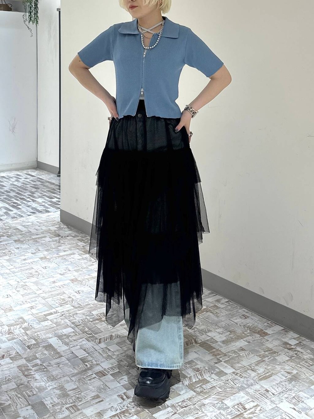 ブラック系のスニーカー、ブルー系のデニムパンツ、ブラック系のスカートを着用したレディースの春コーディネートの5枚目の写真