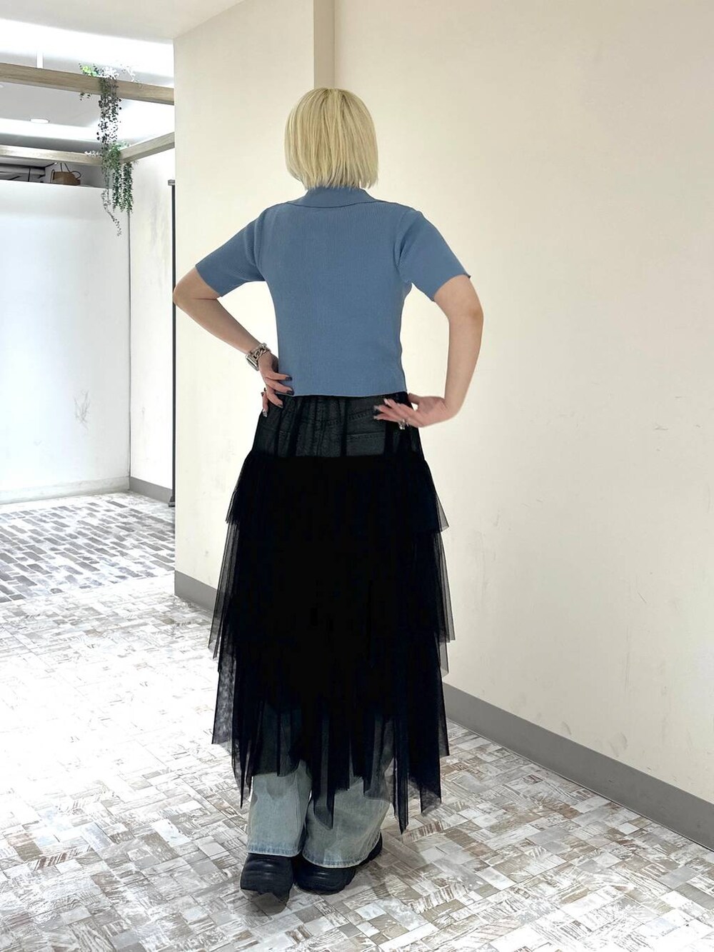 ブラック系のスニーカー、ブルー系のデニムパンツ、ブラック系のスカートを着用したレディースの春コーディネートの4枚目の写真