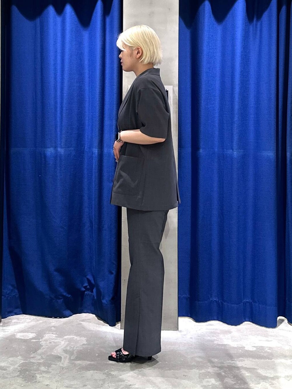 ブラック系のサンダル、ホワイト系のTシャツ/カットソー、グレー系のテーラードジャケットを着用したレディースの夏コーディネートの2枚目の写真