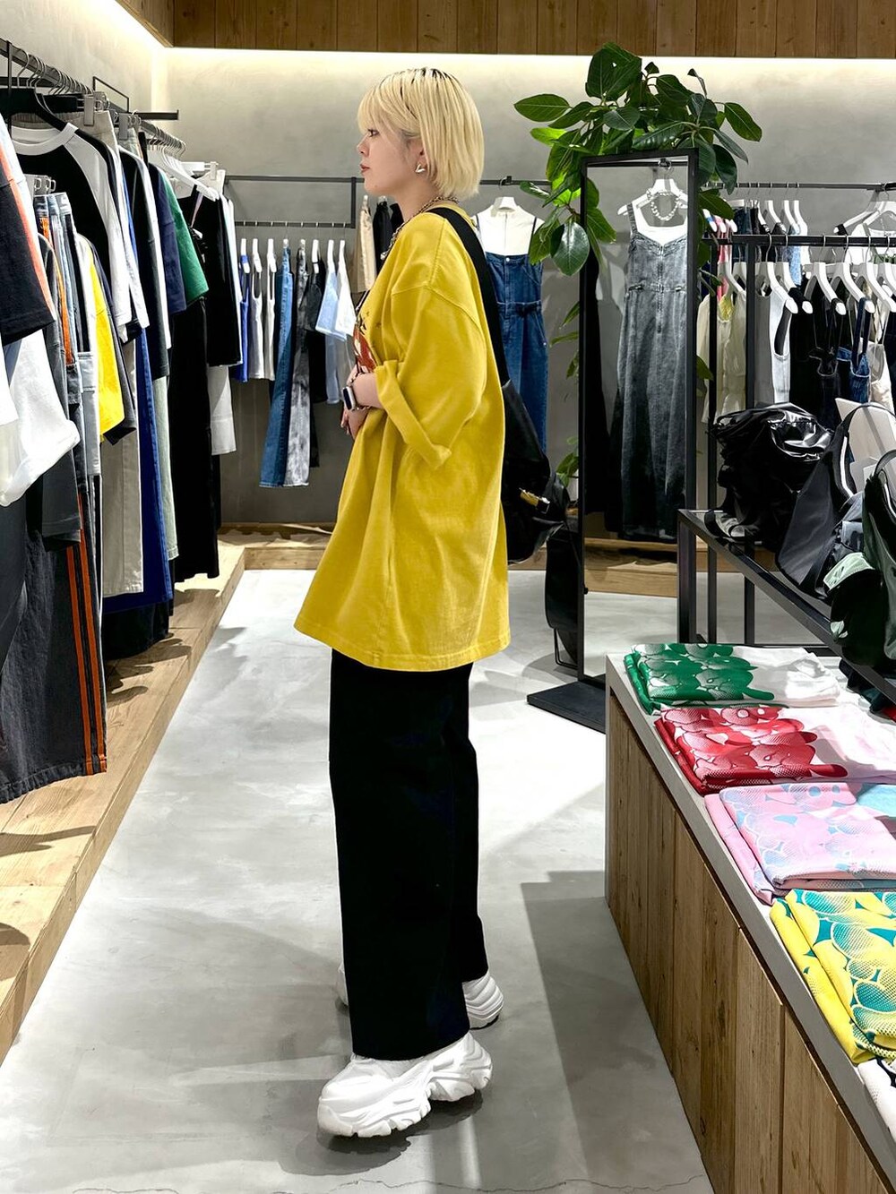 ブラック系のショルダーバッグ、ブラック系のその他パンツ、ホワイト系のスニーカーを着用したレディースの夏コーディネートの2枚目の写真