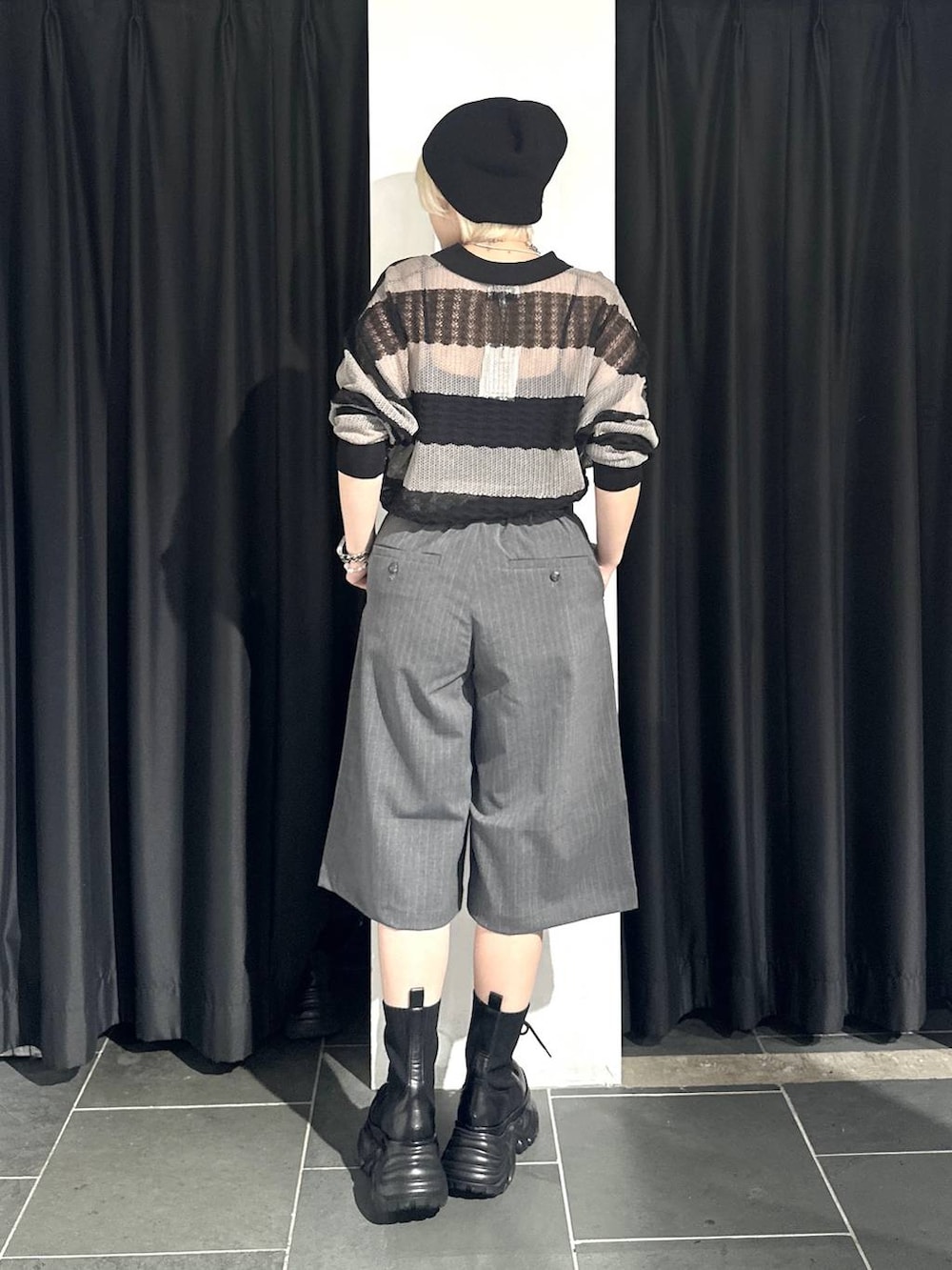 ブラック系のブーツ、グレー系のポロシャツ、グレー系のスラックスを着用したレディースの春コーディネートの4枚目の写真