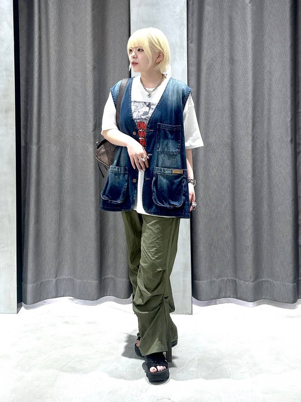 ブラウン系のショルダーバッグ、ホワイト系のTシャツ/カットソー、グリーン系のカーゴパンツを着用したレディースの夏コーディネートの2枚目の写真