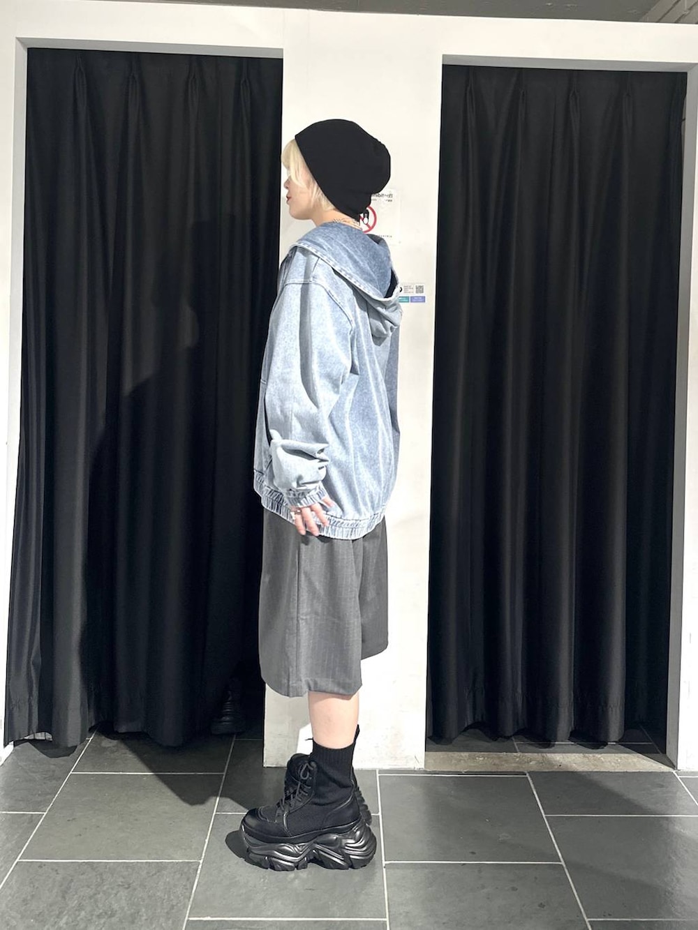 ブラック系のブーツ、ブルー系のパーカー、グレー系のスラックスを着用したレディースの春コーディネートの3枚目の写真