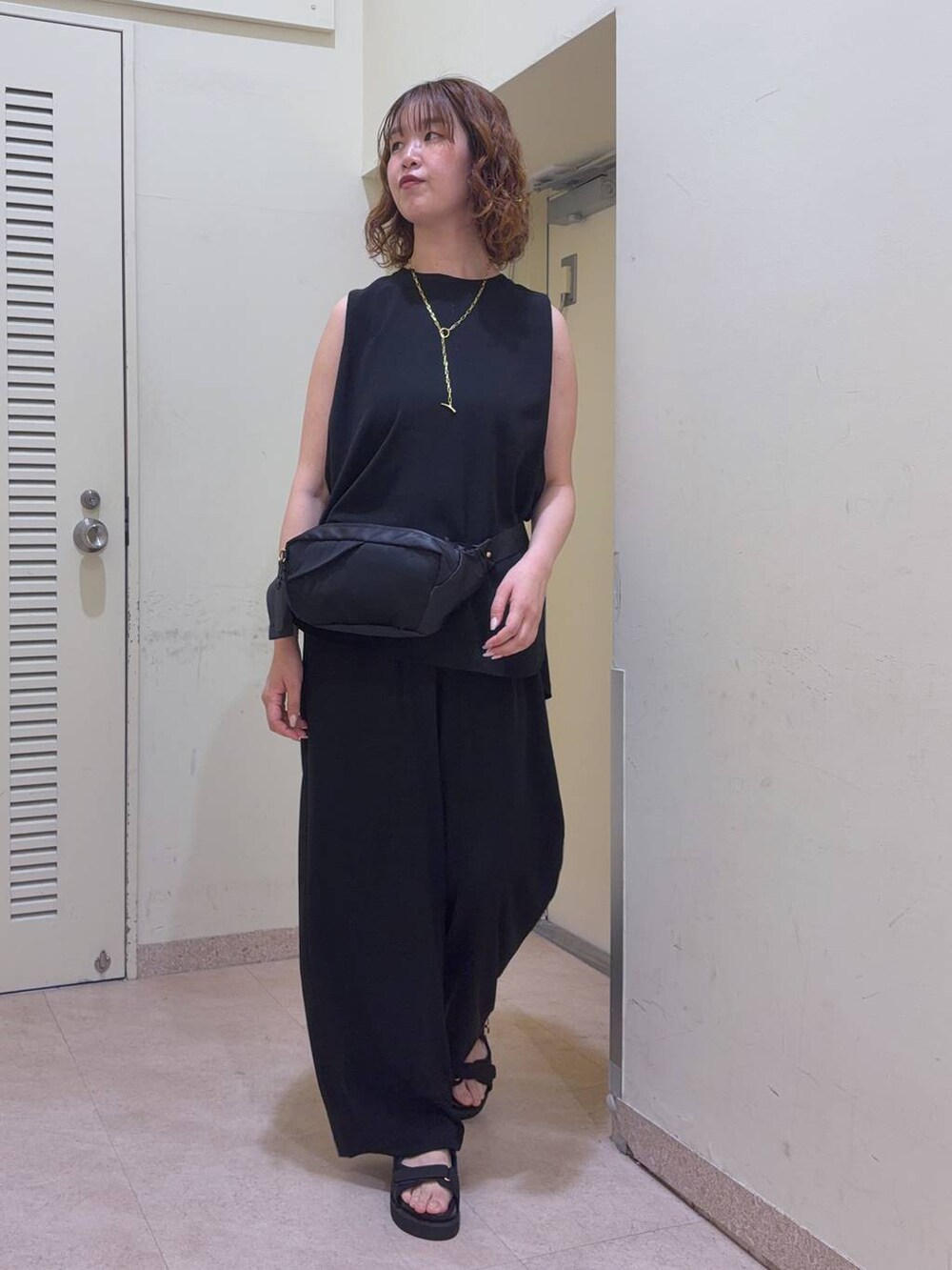 ブラック系のその他パンツ、ブラック系のボディバッグ/ウエストポーチ、ブラック系のサンダルを着用したレディースの夏コーディネートの2枚目の写真