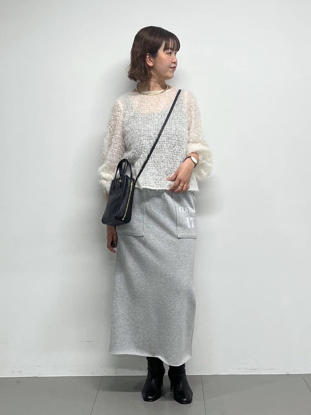 ブラック系のブーツ、ホワイト系のシャツ/ブラウス、ブラック系のショルダーバッグを着用したレディースの冬コーディネートの2枚目の写真