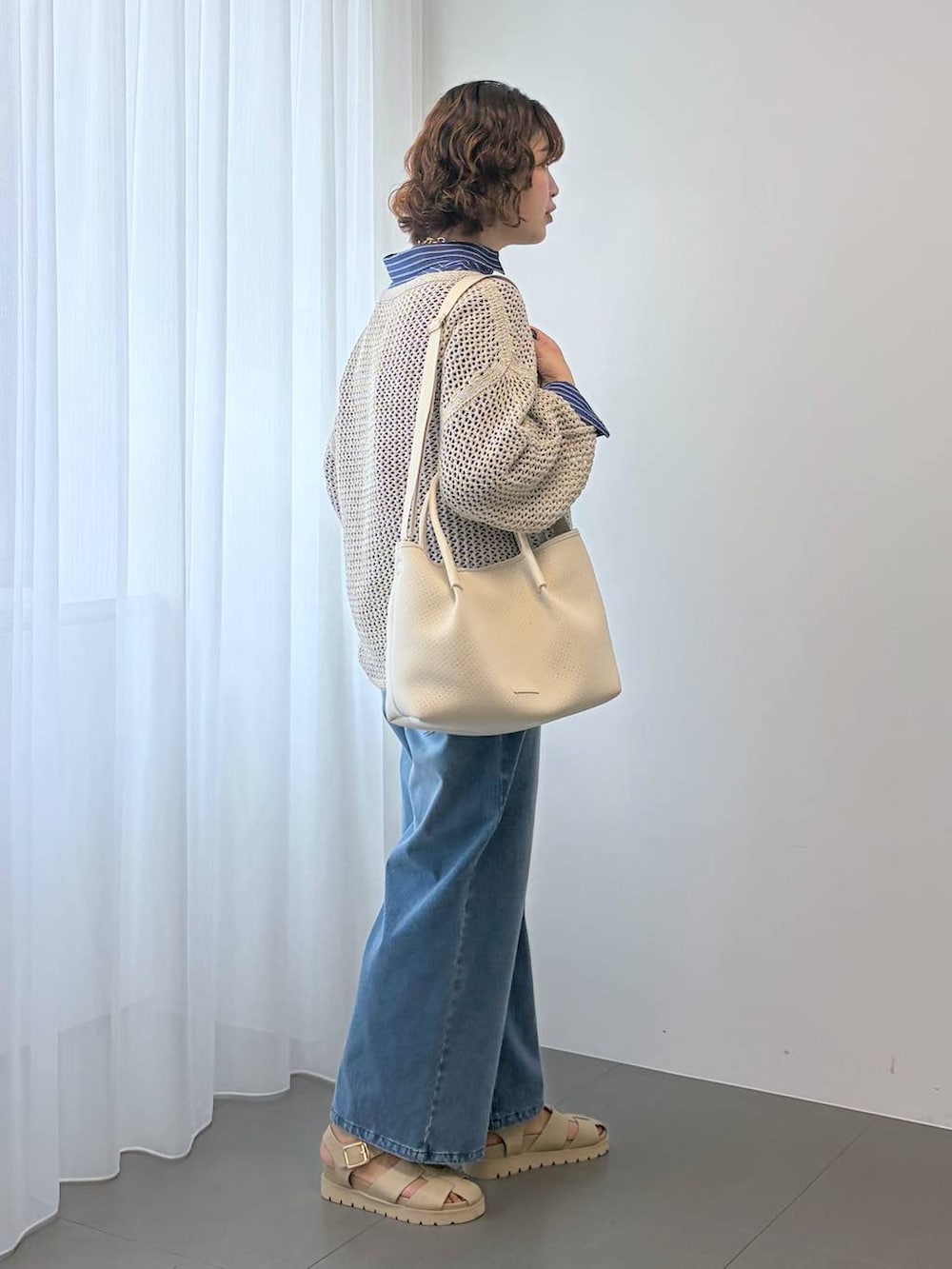 ベージュ系のニット/セーター、ブルー系のデニムパンツ、ホワイト系のトートバッグを着用したレディースの冬コーディネートの7枚目の写真