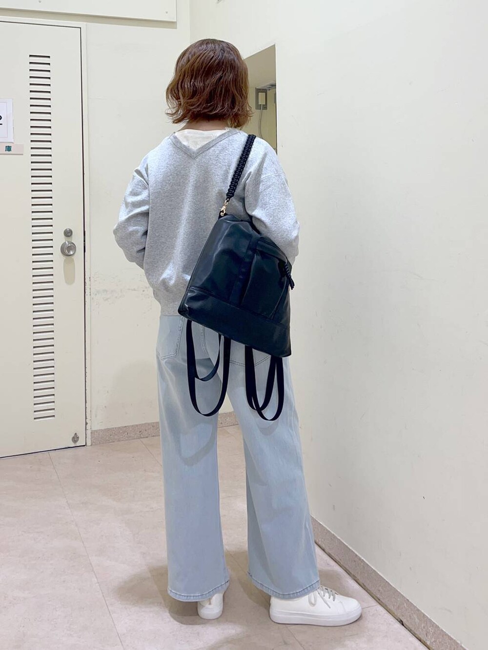 ブラック系のバックパック/リュック、グレー系のカーディガン/ボレロ、ホワイト系のTシャツ/カットソーを着用したレディースの冬コーディネートの4枚目の写真