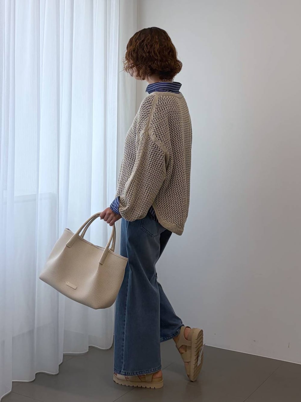 ベージュ系のニット/セーター、ブルー系のデニムパンツ、ホワイト系のトートバッグを着用したレディースの冬コーディネートの5枚目の写真