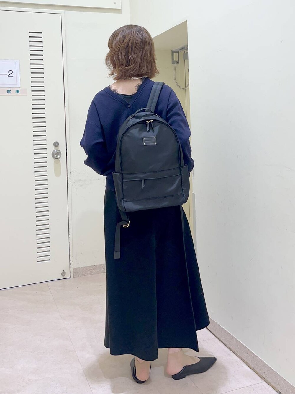 ブラック系のバックパック/リュック、ブラック系のスカート、ブルー系のカーディガン/ボレロを着用したレディースの冬コーディネートの4枚目の写真