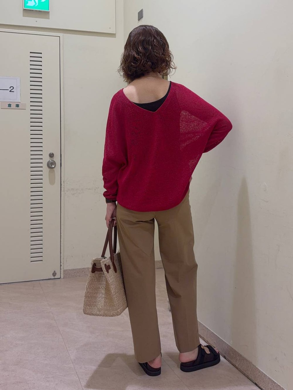 ベージュ系のその他パンツ、レッド系のニット/セーター、ベージュ系のかごバッグを着用したレディースの春コーディネートの6枚目の写真