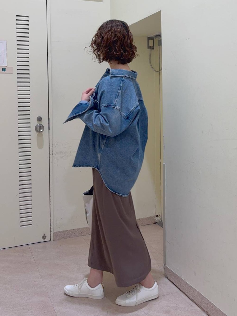 ブルー系のシャツ/ブラウス、ホワイト系のトートバッグ、グリーン系のスカートを着用したレディースの冬コーディネートの3枚目の写真