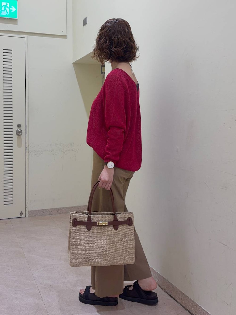 ベージュ系のその他パンツ、レッド系のニット/セーター、ベージュ系のかごバッグを着用したレディースの春コーディネートの4枚目の写真