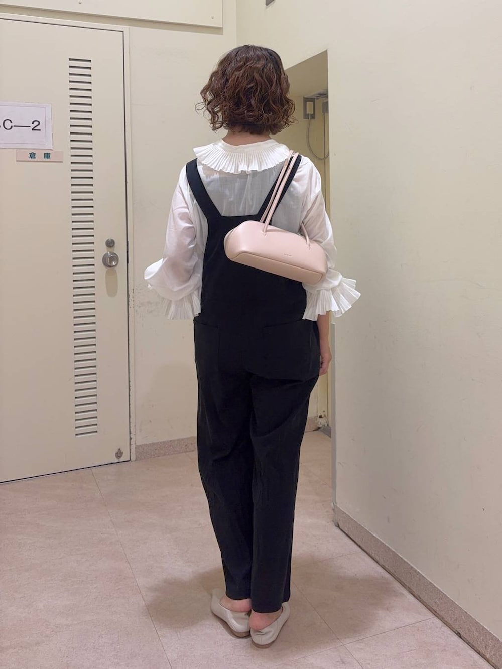 ブラック系のサロペット/オーバーオール、ホワイト系のシャツ/ブラウス、ピンク系のハンドバッグを着用したレディースの冬コーディネートの4枚目の写真