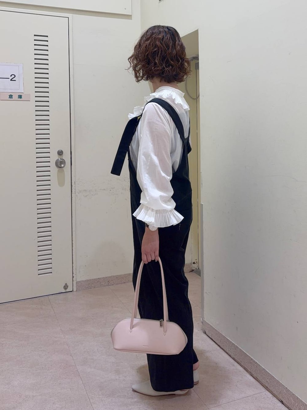 ブラック系のサロペット/オーバーオール、ホワイト系のシャツ/ブラウス、ピンク系のハンドバッグを着用したレディースの冬コーディネートの3枚目の写真