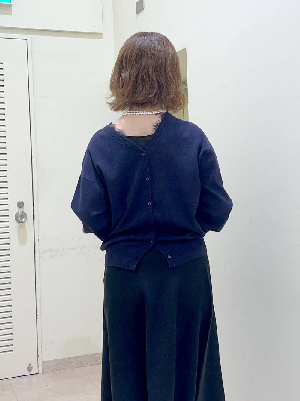 ブラック系のバックパック/リュック、ブラック系のスカート、ブルー系のカーディガン/ボレロを着用したレディースの冬コーディネートの5枚目の写真