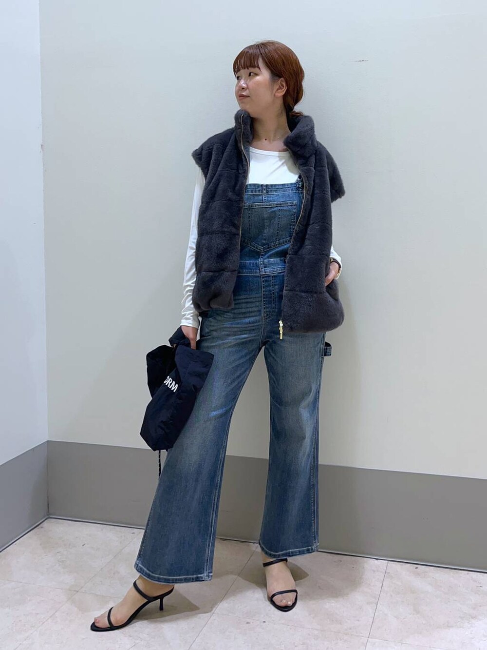 その他のサンダル、ブラック系のトートバッグ、ブルー系のサロペット/オーバーオールを着用したレディースの秋コーディネートの2枚目の写真