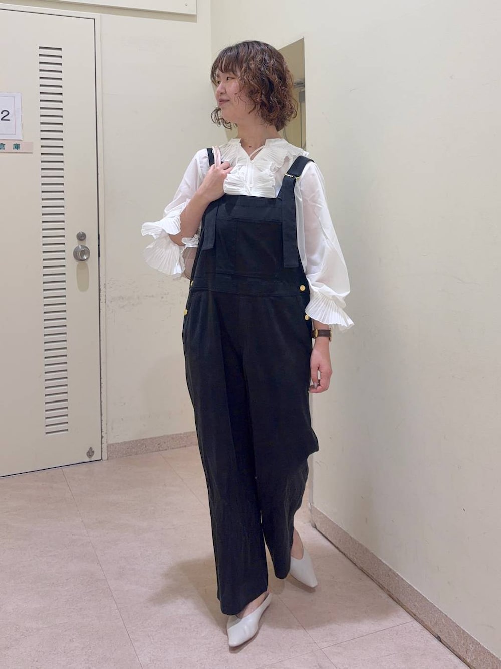 ブラック系のサロペット/オーバーオール、ホワイト系のシャツ/ブラウス、ピンク系のハンドバッグを着用したレディースの冬コーディネートの2枚目の写真