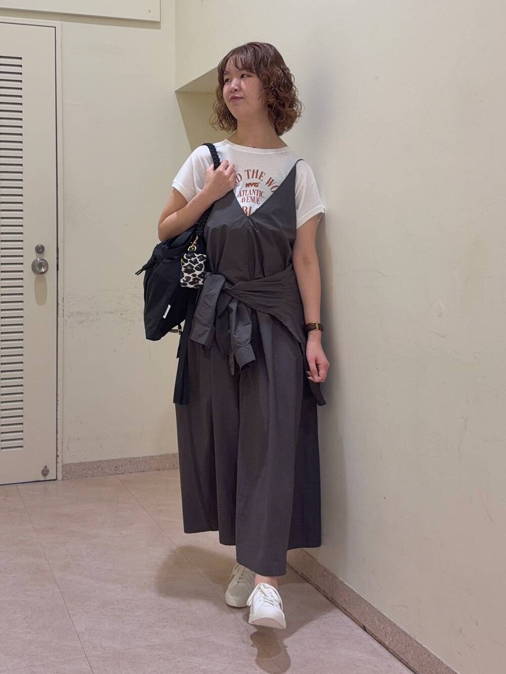 グレー系のシャツ/ブラウス、ホワイト系のTシャツ/カットソー、ブラック系のバックパック/リュックを着用したレディースの春コーディネートの2枚目の写真