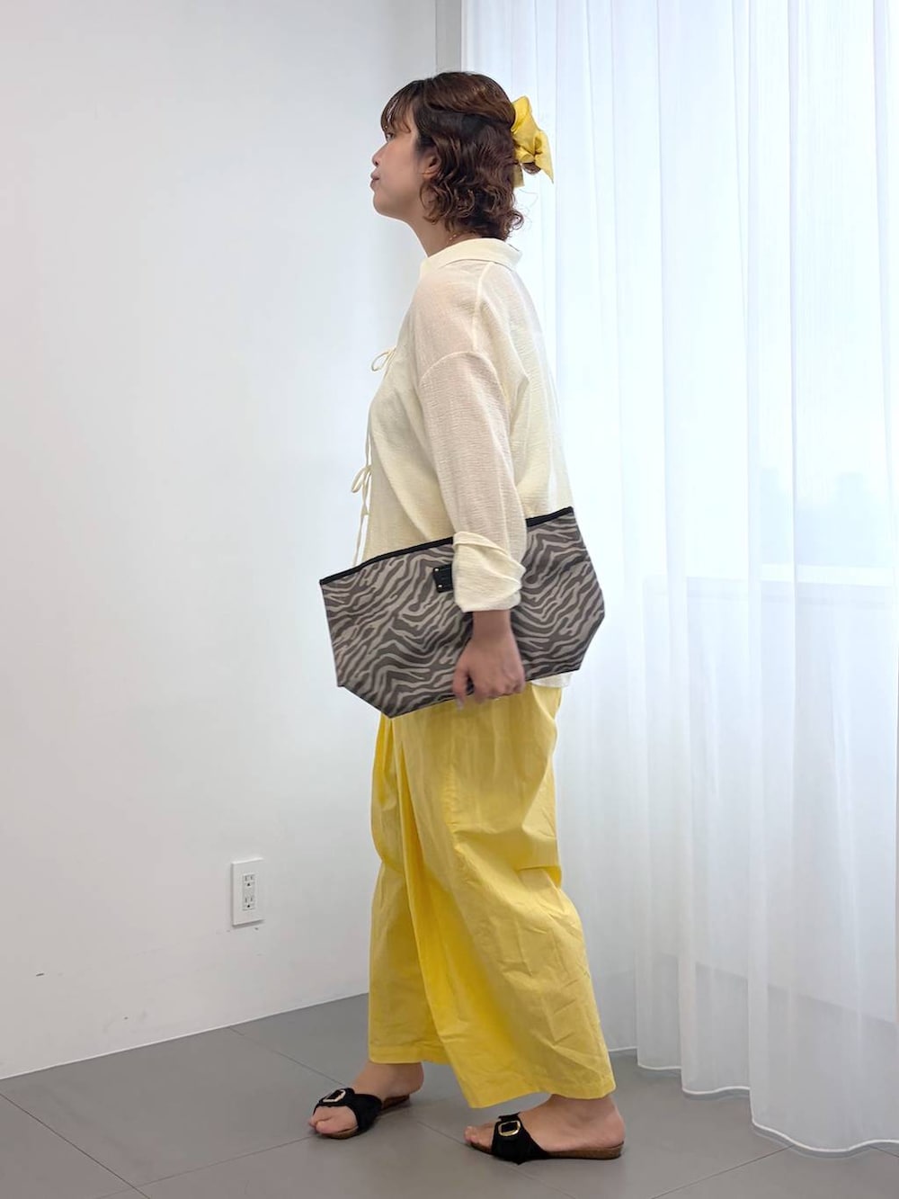 イエロー系のその他パンツ、グレー系のトートバッグ、ホワイト系のキャミソールを着用したレディースの春コーディネートの2枚目の写真