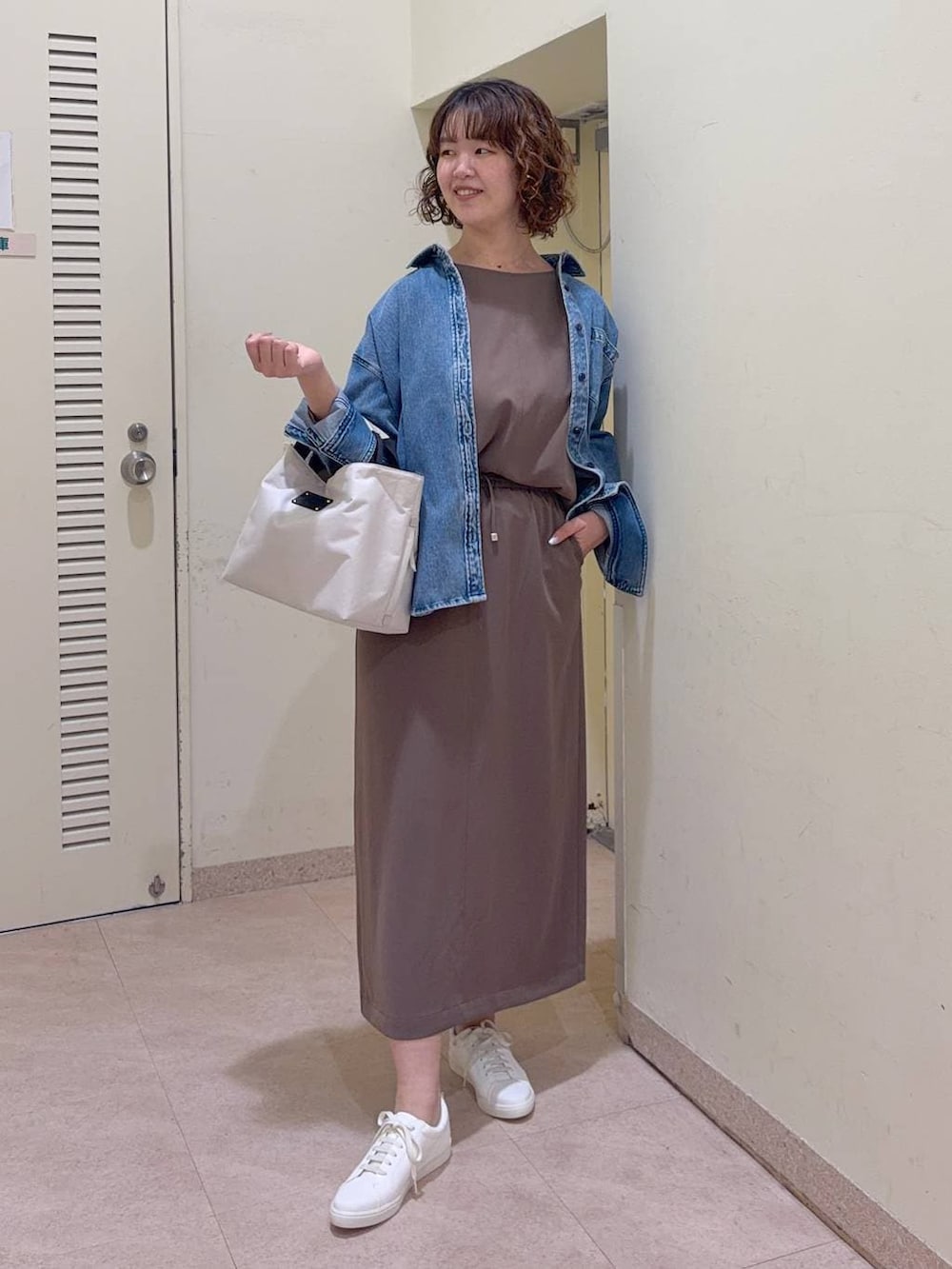 ブルー系のシャツ/ブラウス、ホワイト系のトートバッグ、グリーン系のスカートを着用したレディースの冬コーディネートの2枚目の写真