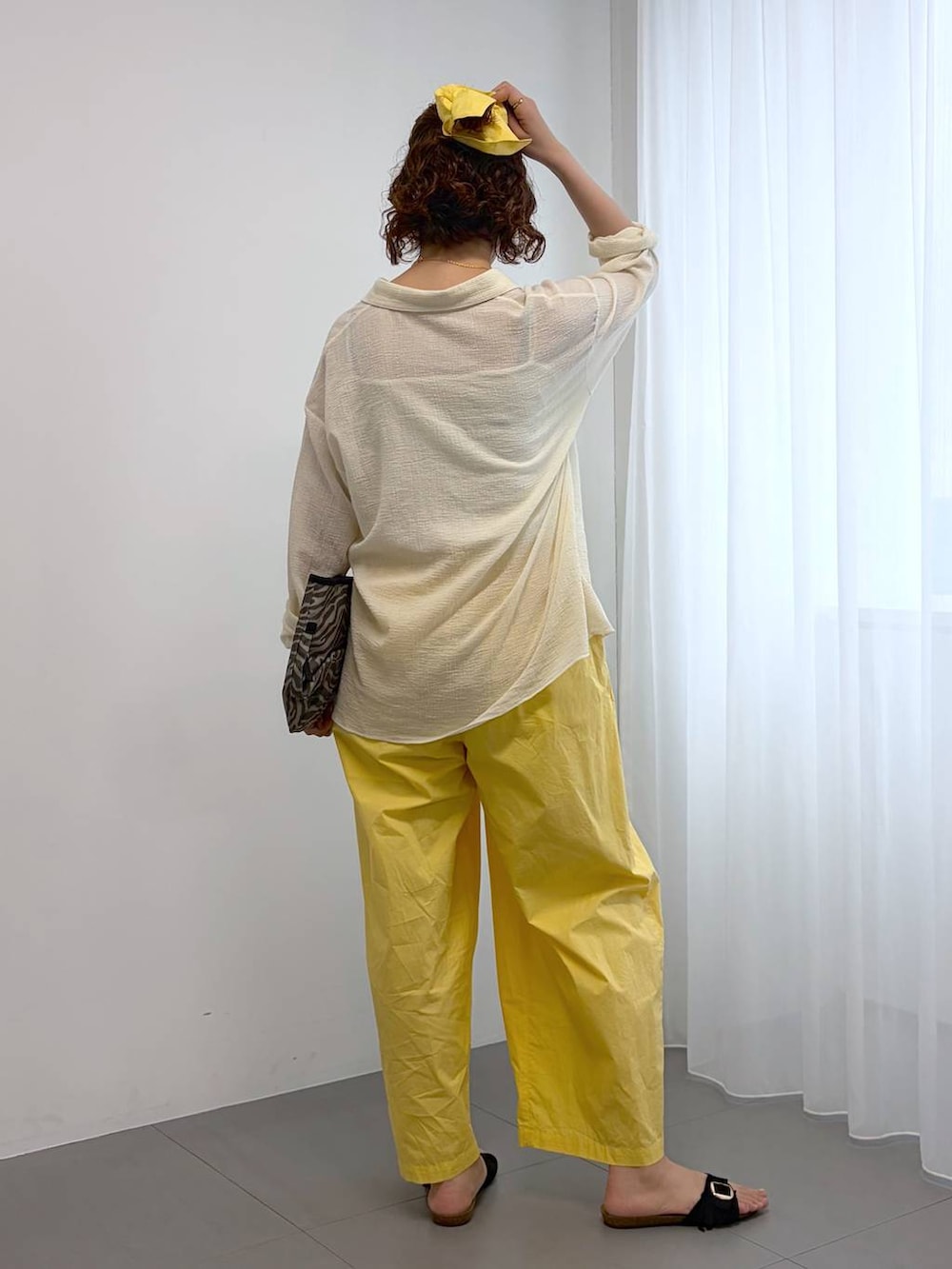 イエロー系のその他パンツ、グレー系のトートバッグ、ホワイト系のキャミソールを着用したレディースの春コーディネートの3枚目の写真