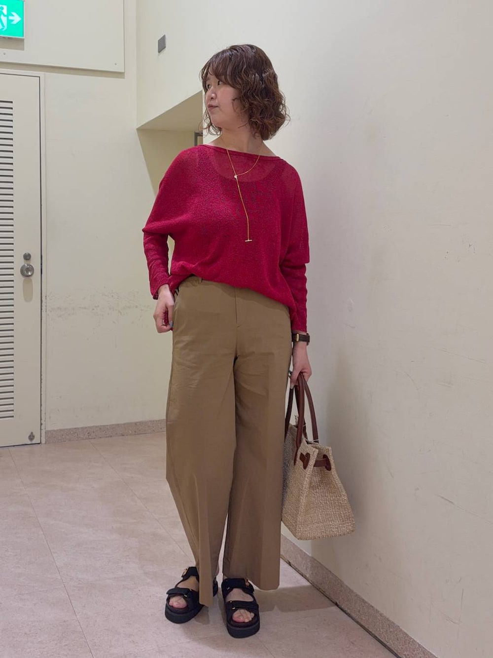 ベージュ系のその他パンツ、レッド系のニット/セーター、ベージュ系のかごバッグを着用したレディースの春コーディネートの3枚目の写真