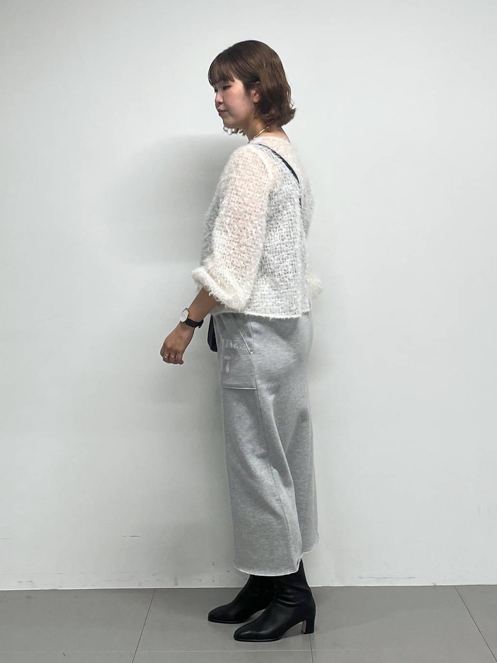 ブラック系のブーツ、ホワイト系のシャツ/ブラウス、ブラック系のショルダーバッグを着用したレディースの冬コーディネートの3枚目の写真