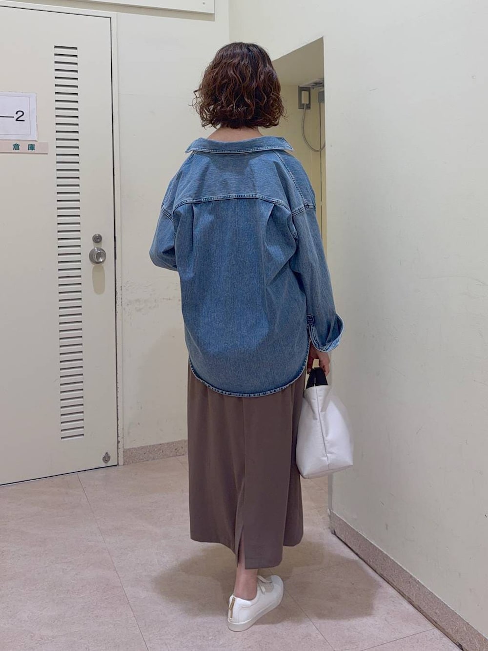 ブルー系のシャツ/ブラウス、ホワイト系のトートバッグ、グリーン系のスカートを着用したレディースの冬コーディネートの4枚目の写真