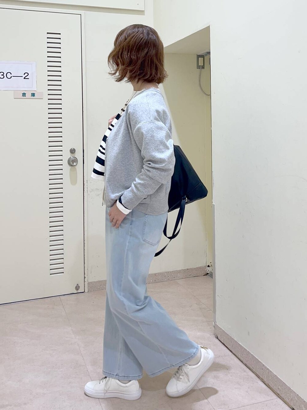 ブラック系のバックパック/リュック、グレー系のカーディガン/ボレロ、ホワイト系のTシャツ/カットソーを着用したレディースの冬コーディネートの2枚目の写真