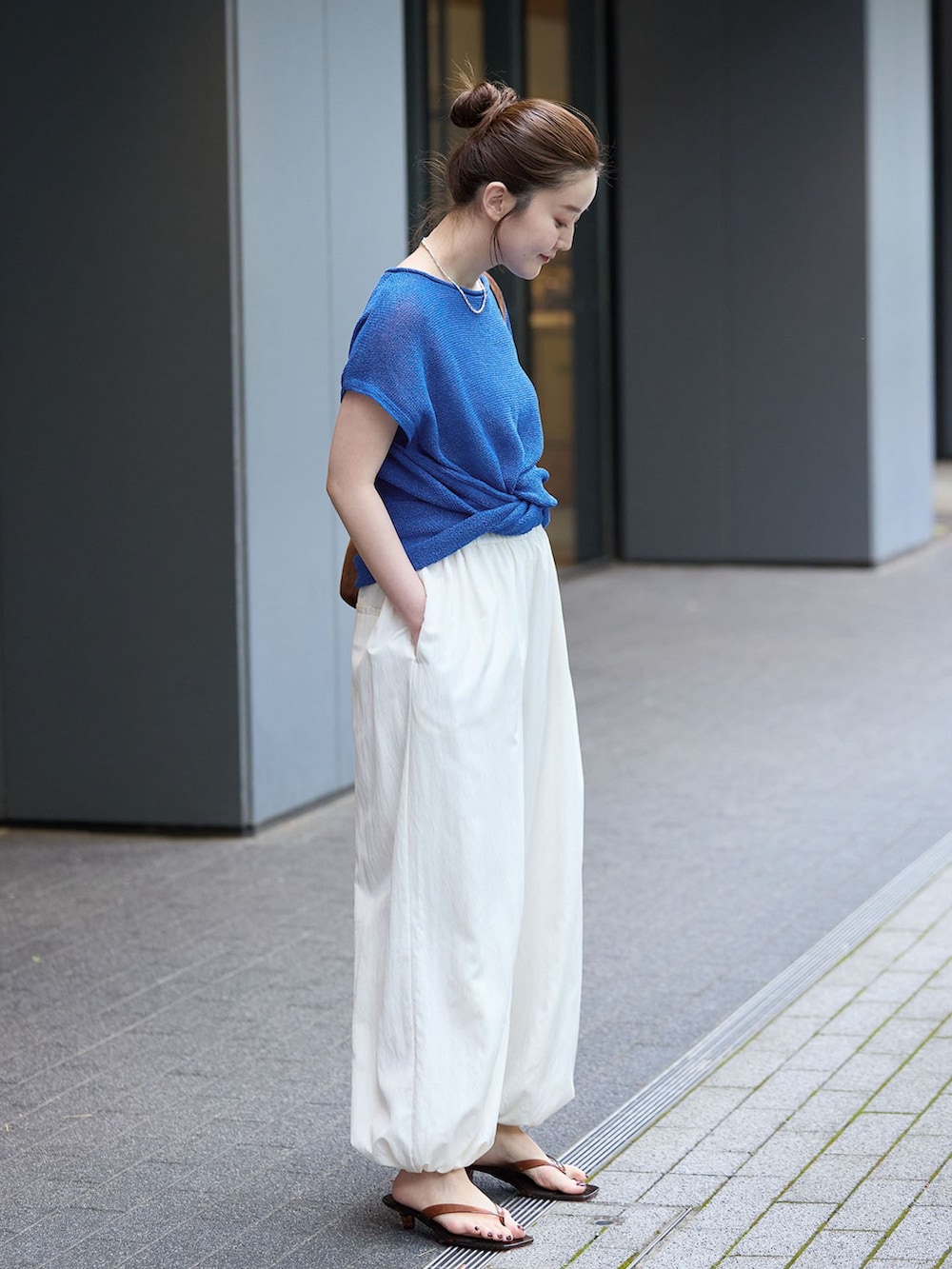 ホワイト系のその他パンツ、ブルー系のニット/セーター、ブラウン系のショルダーバッグを着用したレディースの夏コーディネートの2枚目の写真