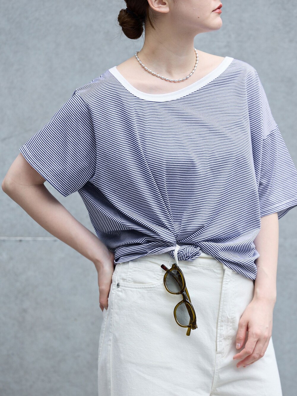 ホワイト系のチノパンツ、ブルー系のTシャツ/カットソー、ブラウン系のサンダルを着用したレディースの春コーディネートの5枚目の写真