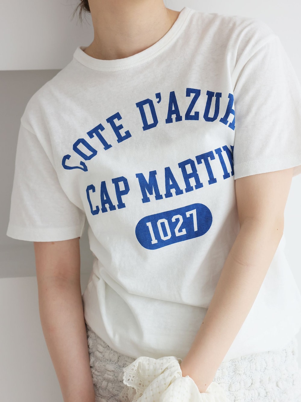 ブルー系のデニムパンツ、ホワイト系のスカート、ホワイト系のTシャツ/カットソーを着用したレディースの春コーディネートの5枚目の写真
