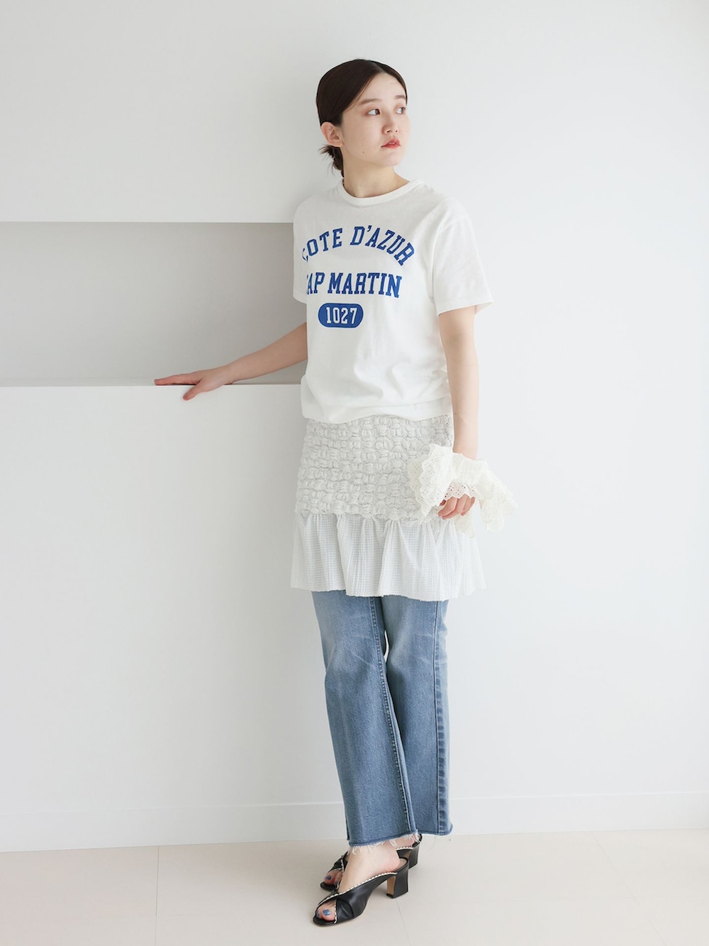 ブルー系のデニムパンツ、ホワイト系のスカート、ホワイト系のTシャツ/カットソーを着用したレディースの春コーディネートの3枚目の写真