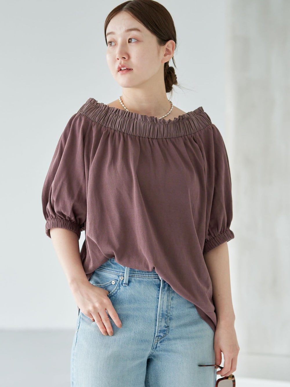 ブルー系のデニムパンツ、ブラウン系のニット/セーターを着用したレディースの夏コーディネートの4枚目の写真