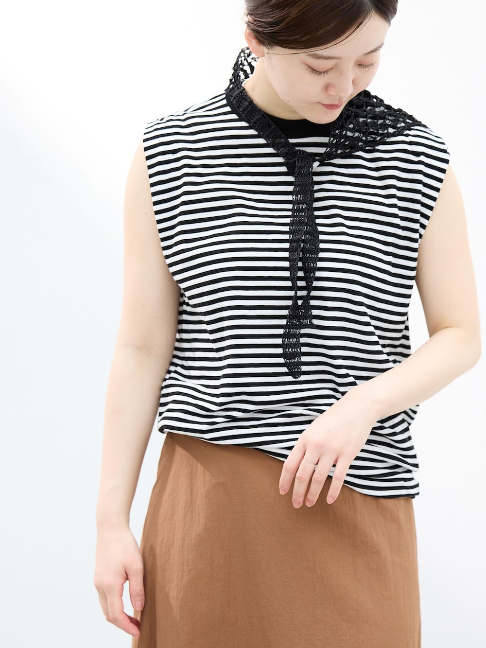 イエロー系のスカート、ブラック系のTシャツ/カットソー、ブラック系のサンダルを着用したレディースの春コーディネートの4枚目の写真