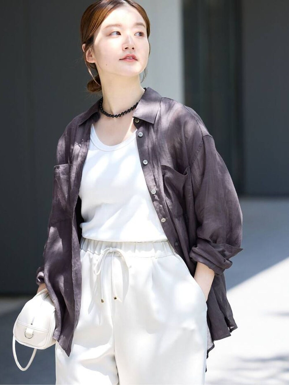 ベージュ系のその他パンツ、ブラック系のシャツ/ブラウス、ホワイト系のショルダーバッグを着用したレディースの春コーディネートの4枚目の写真