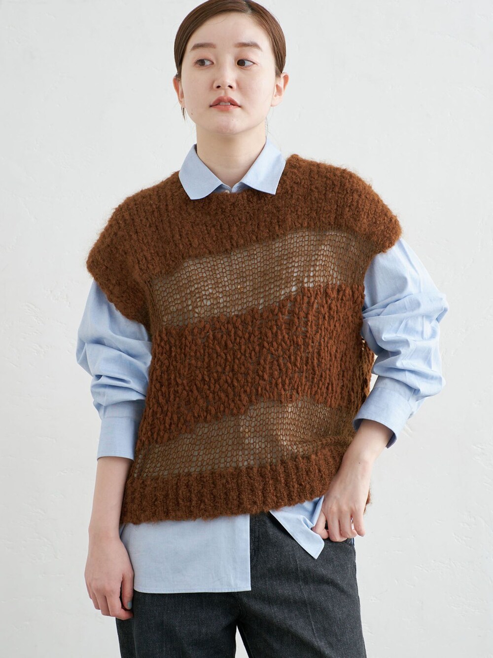 ブラック系のデニムパンツ、ブルー系のシャツ/ブラウス、ブラウン系のベストを着用したレディースの秋コーディネートの4枚目の写真