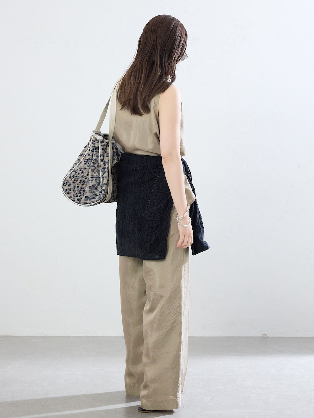 ベージュ系のその他パンツ、ベージュ系のシャツ/ブラウス、ブラウン系のトートバッグを着用したレディースの夏コーディネートの2枚目の写真