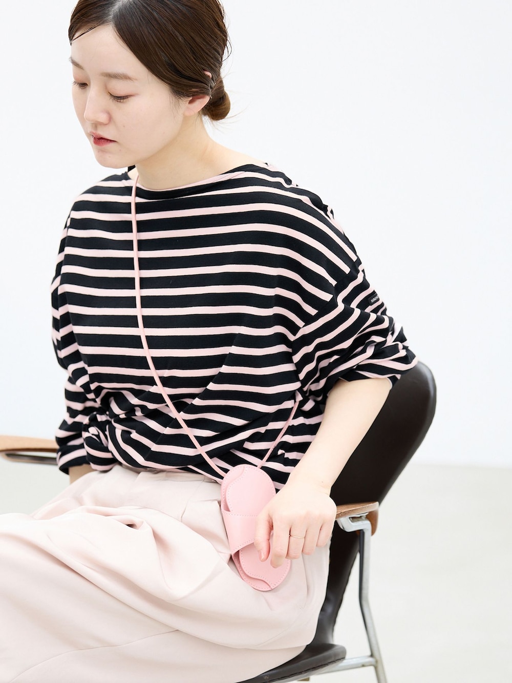 ブラック系のサンダル、ピンク系のその他小物を着用したレディースの春コーディネートの4枚目の写真
