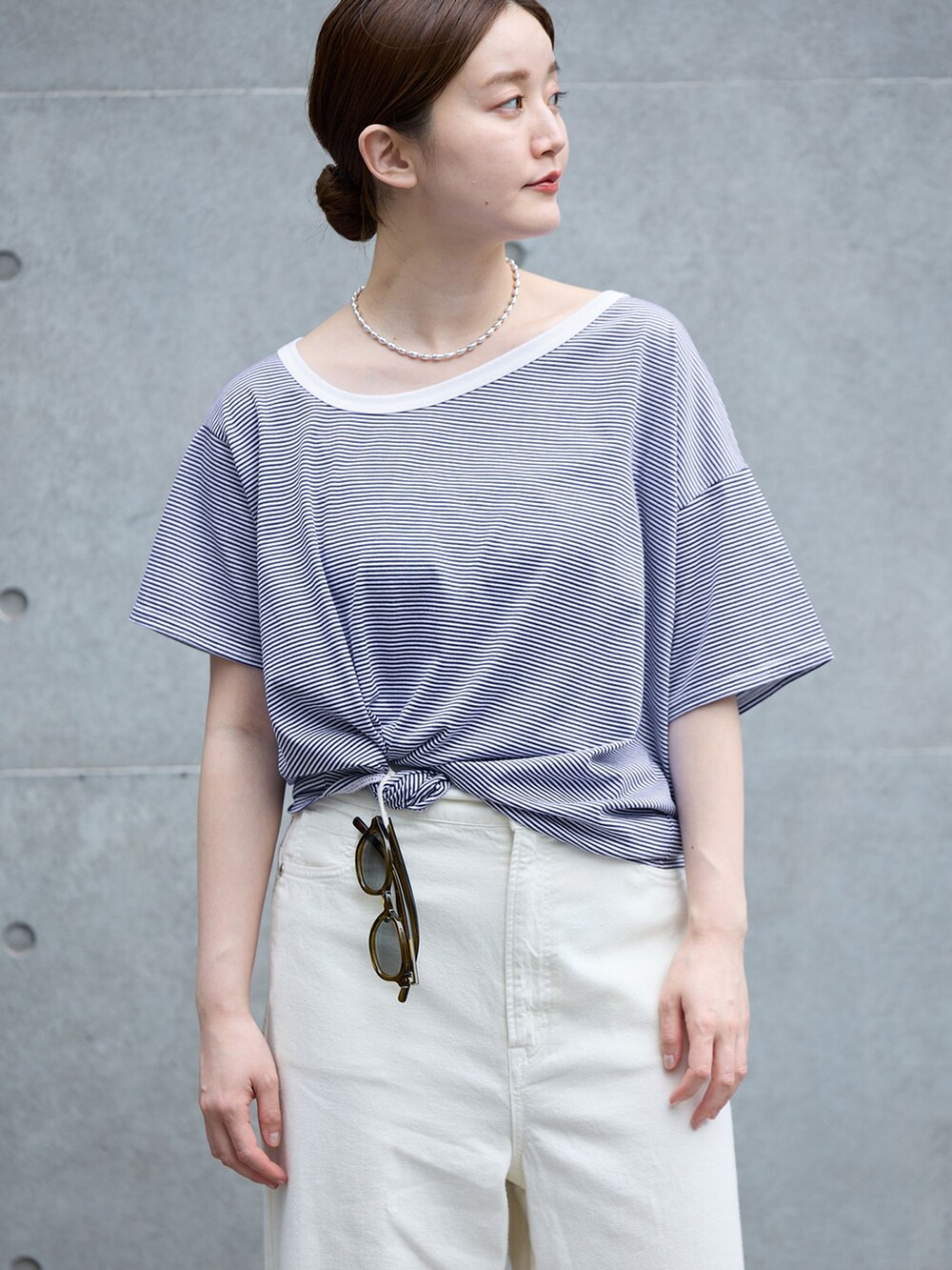 ホワイト系のチノパンツ、ブルー系のTシャツ/カットソー、ブラウン系のサンダルを着用したレディースの春コーディネートの3枚目の写真