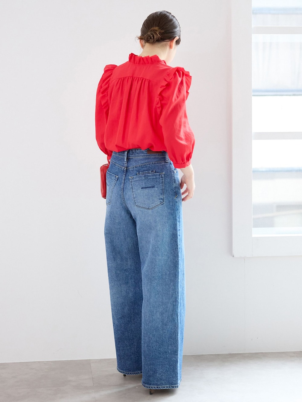 ブルー系のデニムパンツ、レッド系のシャツ/ブラウス、レッド系のショルダーバッグを着用したレディースの春コーディネートの3枚目の写真